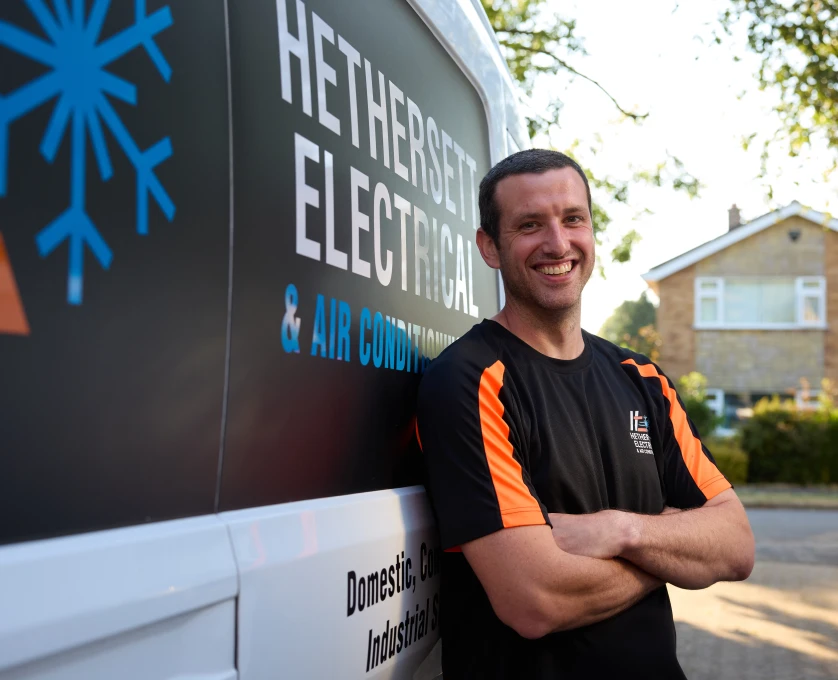 Scott from Hethersett Electrical smiling beside the branded company van