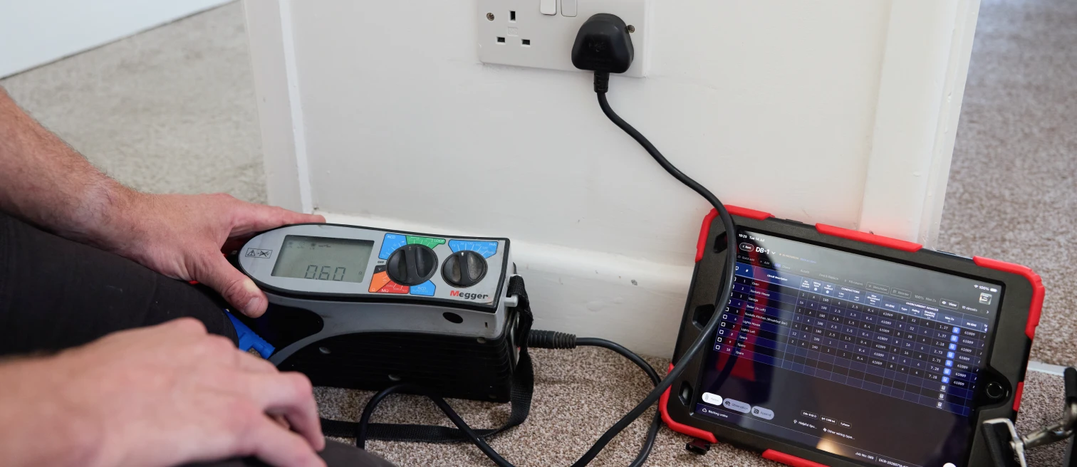 Megger multifunction tester and a tablet recording circuit results during an EICR