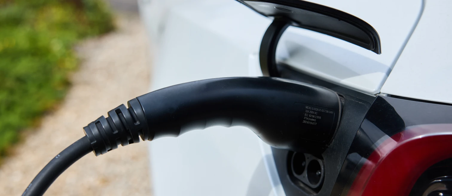 Type 2 charging cable plugged into the charge port of a white electric car