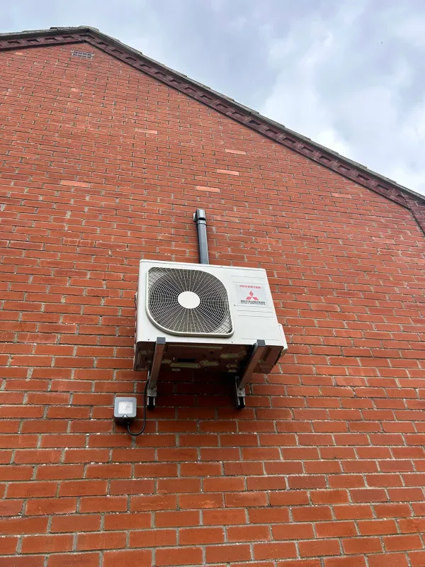 Mitsubishi Heavy Industries air conditioning outdoor unit mounted on a brick wall