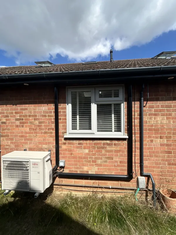 Air conditioning outdoor unit installed beside a window