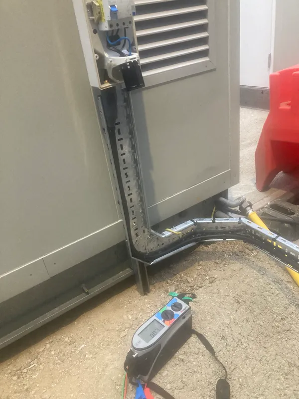 Cable trunking into a commercial distribution board with a Megger tester on the floor