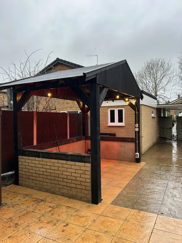 Covered garden gazebo with festoon lighting and an outdoor supply unit