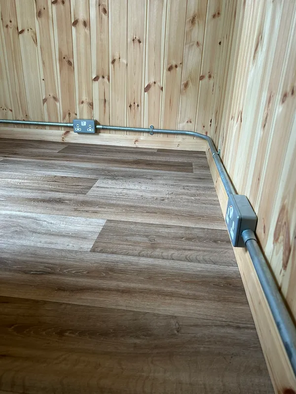 Garden room interior with galvanised conduit and sockets at first fix
