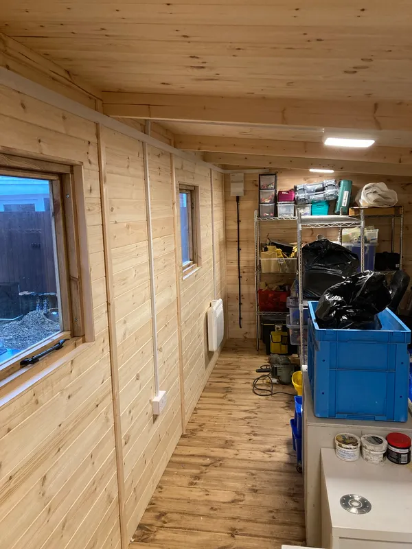Pine-clad garden workshop interior with lighting and power installed