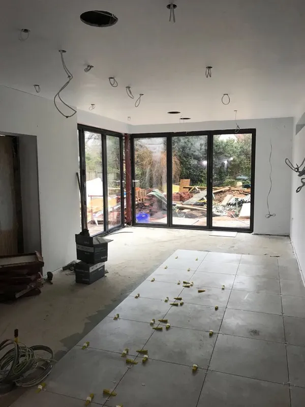 Open-plan kitchen extension at first-fix stage with bifold doors and downlight positions set out