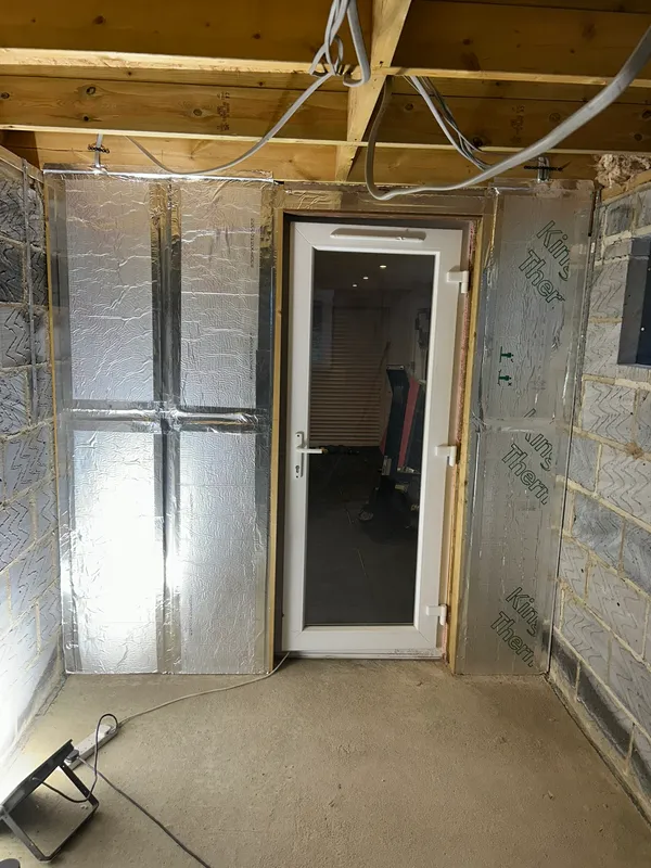 Insulated extension wall at electrical first fix with cabling run above the door